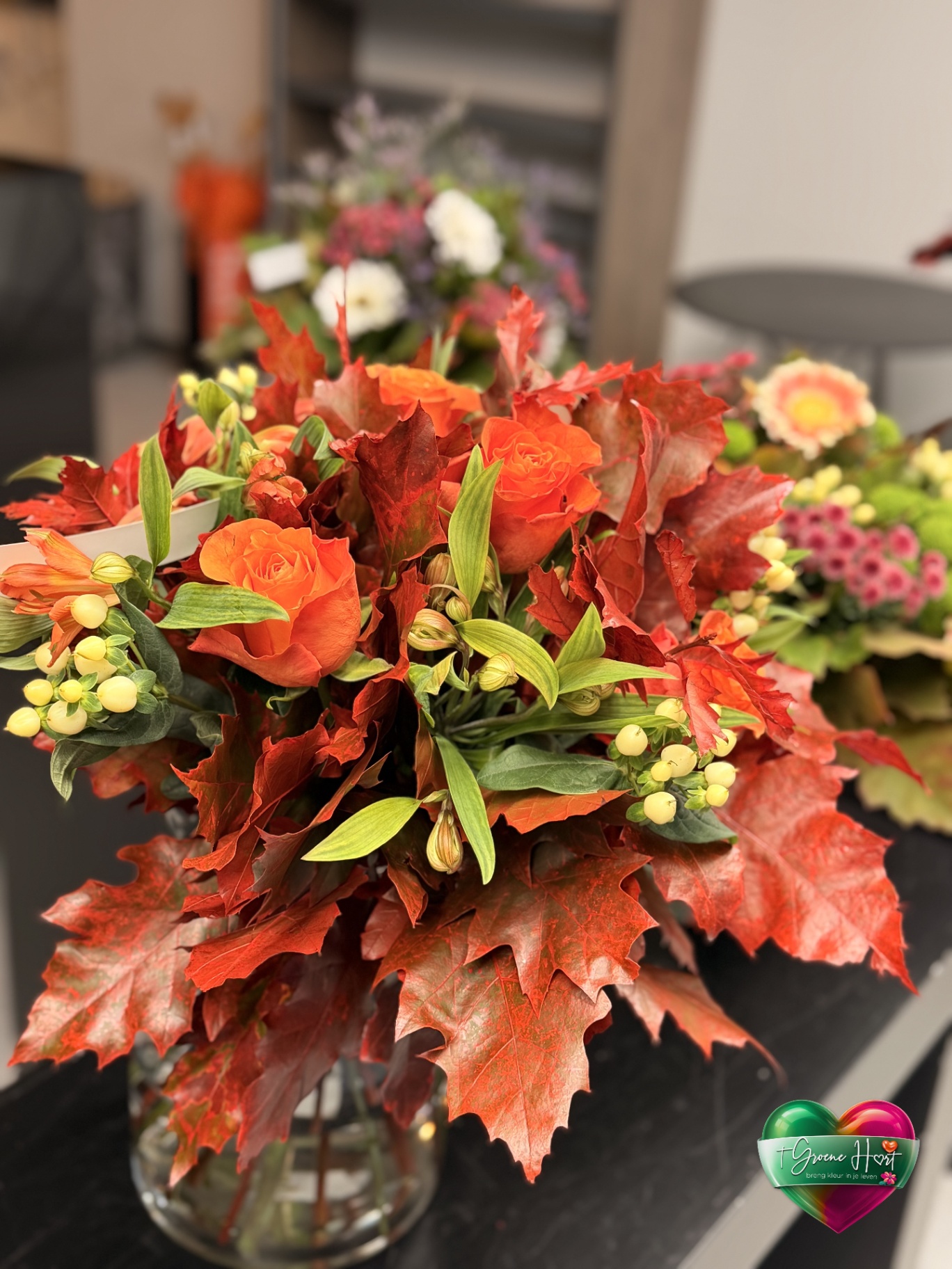 Oranje rozen met alstroemeria en herfstblad