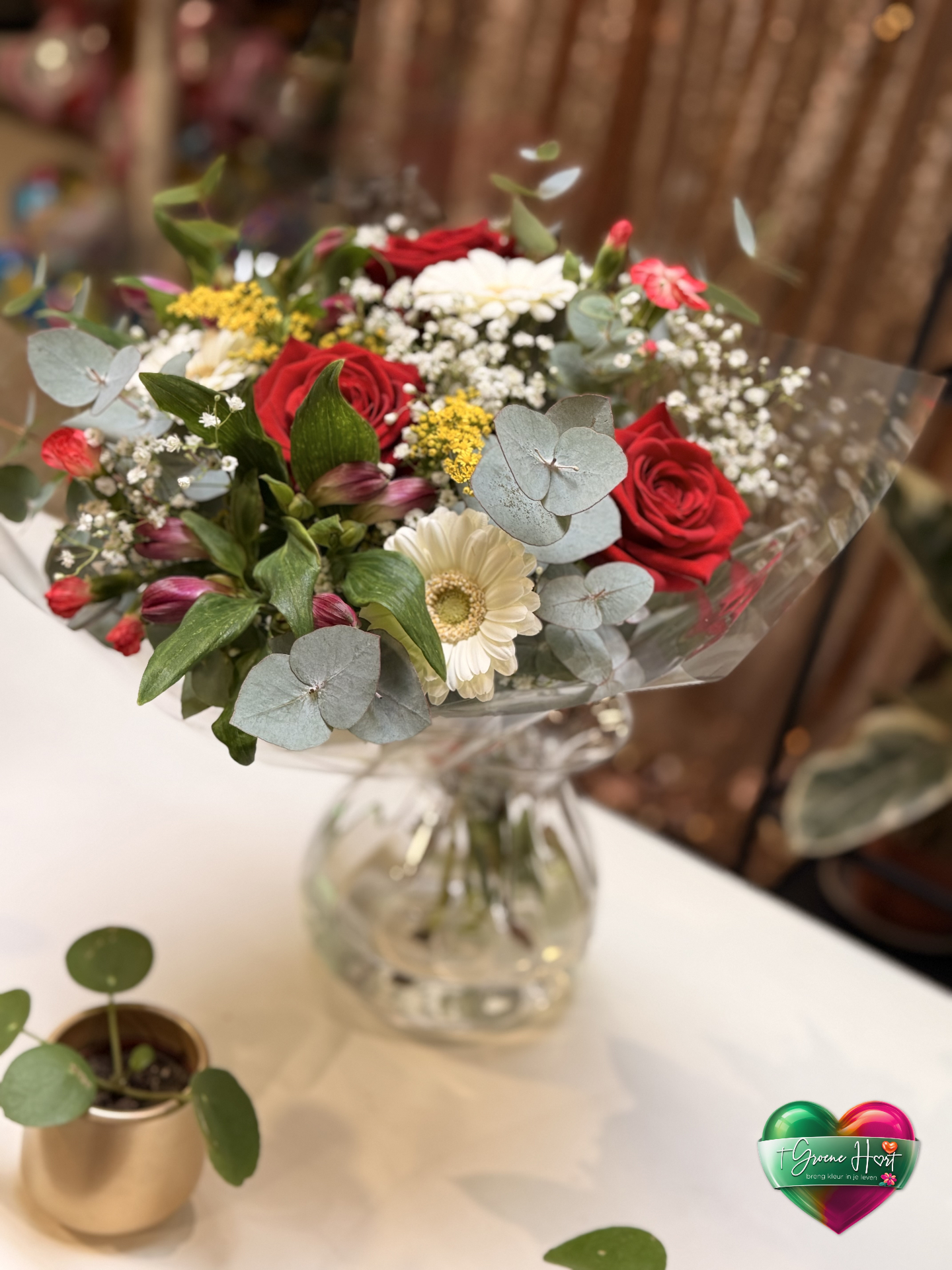 Romantisch boeket met rode rozen, witte gerbera en gipskruid in vaas