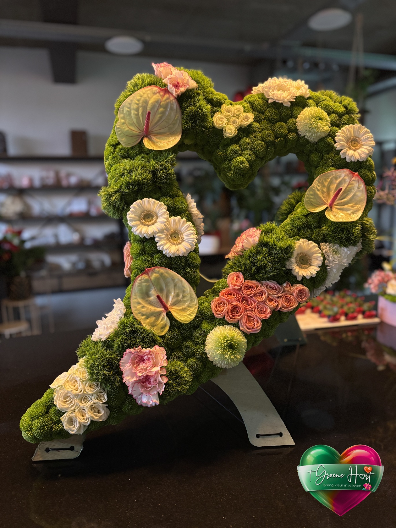 Groen open rouwhart met anthurium, gerbera's en rozen