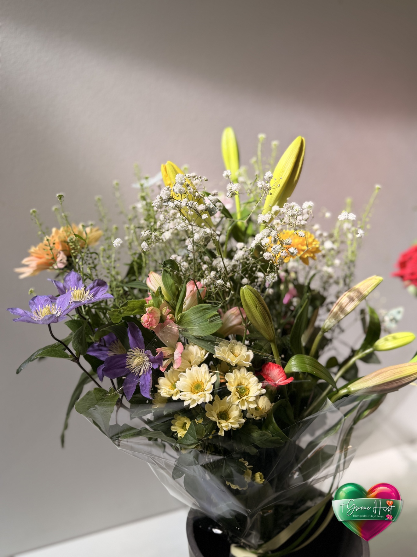 Kleurrijk veldboeket met clematis, lelies en chrysanten