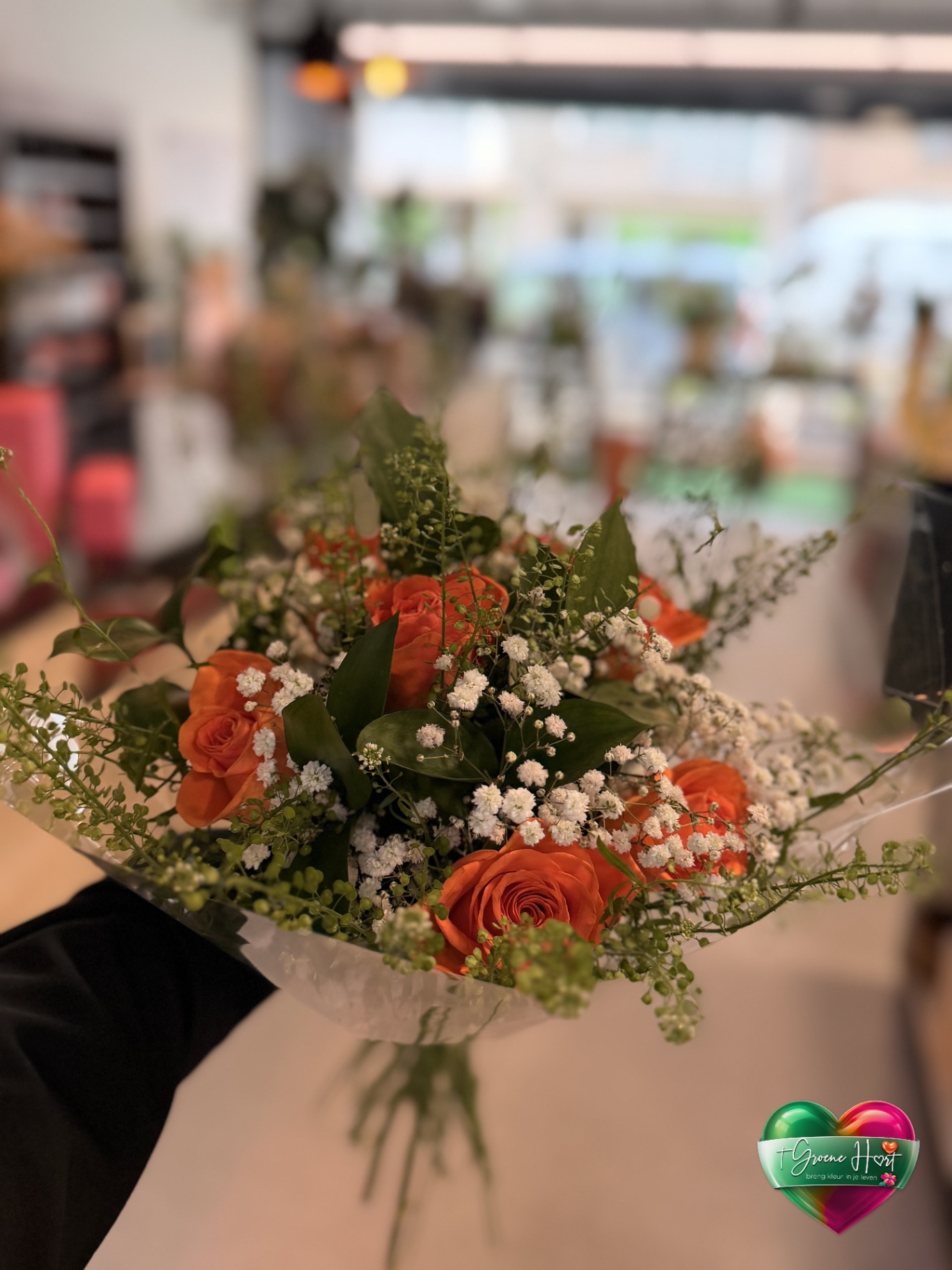 Zacht gemengd boeket met oranje rozen en fijne witte bloemen