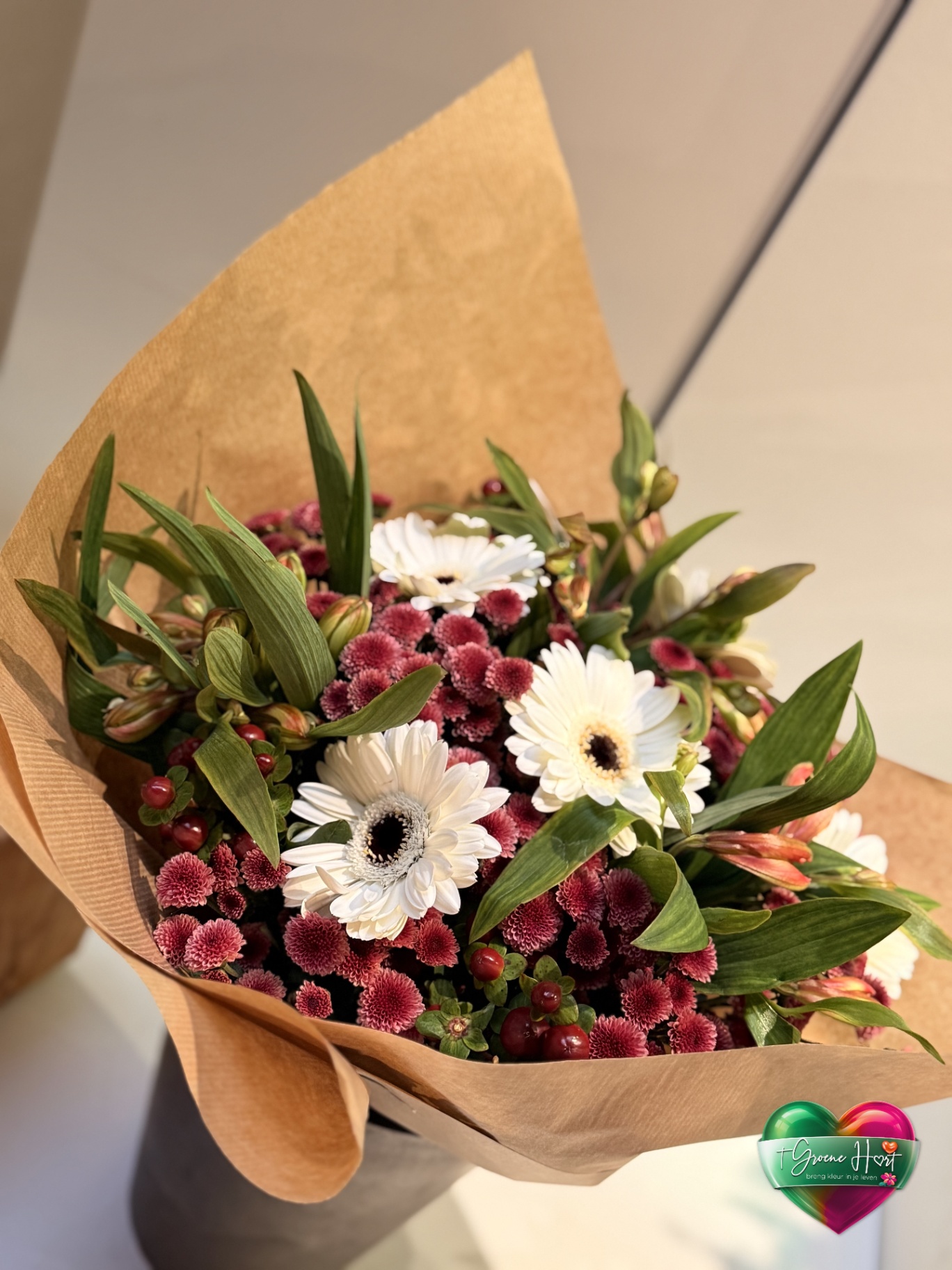 Witte gerbera's met rode bolchrysanten en hypericum bessen