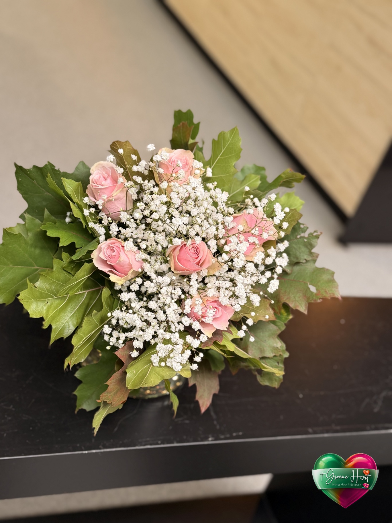 Roze rozen met gipskruid en eikenblad