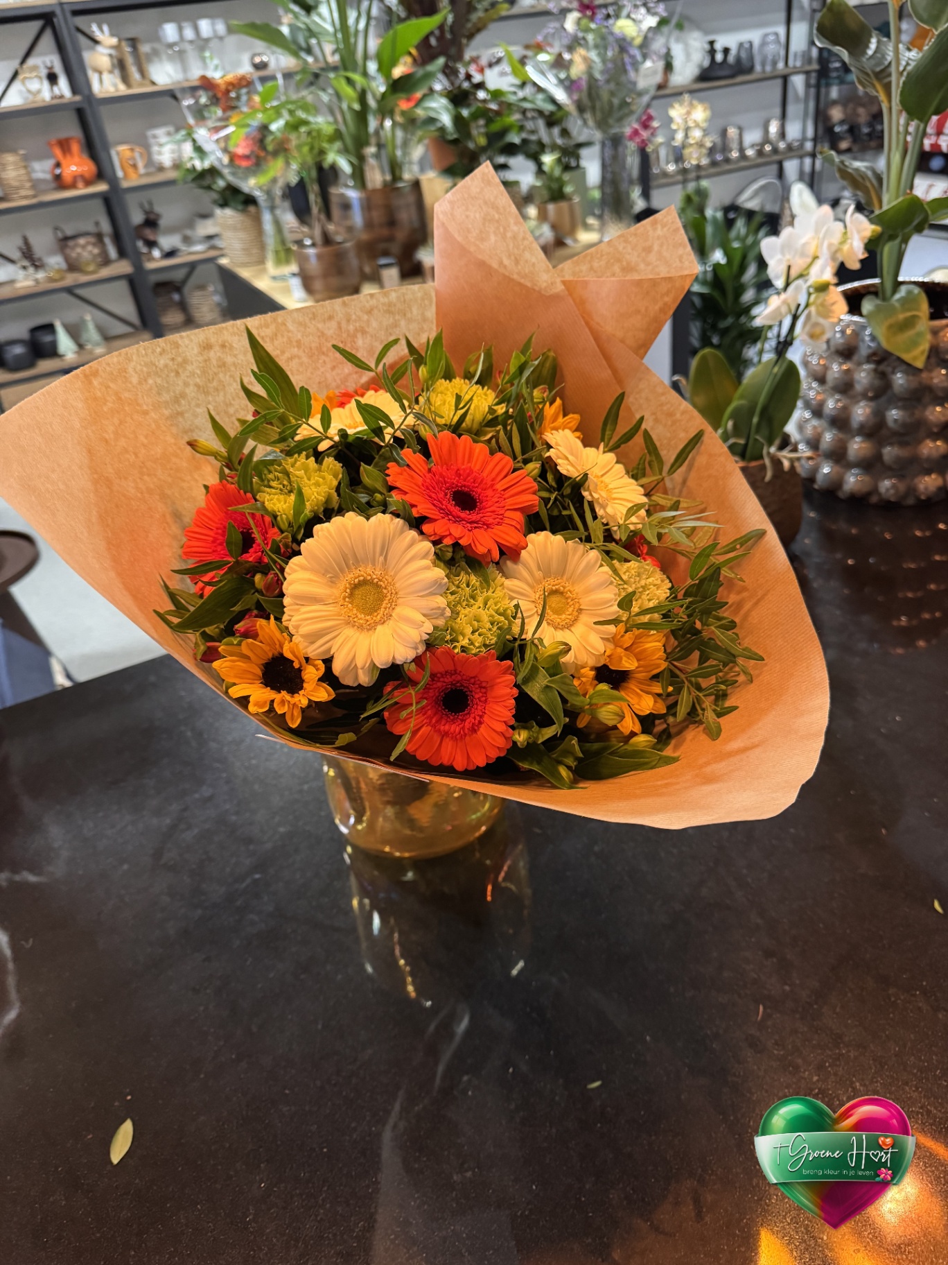 Vrolijk gerberaboeket in oranje en perzik in kraftpapier