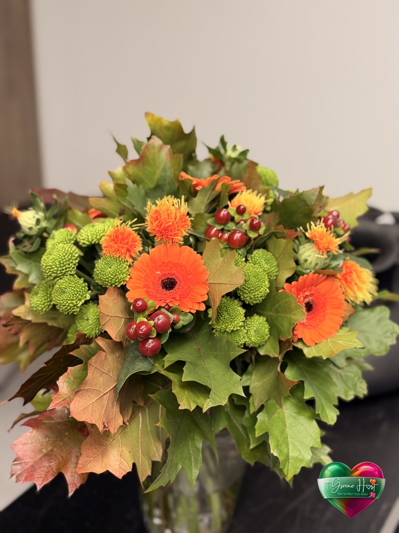 Oranje gerbera's met groene bolchrysanten en distels