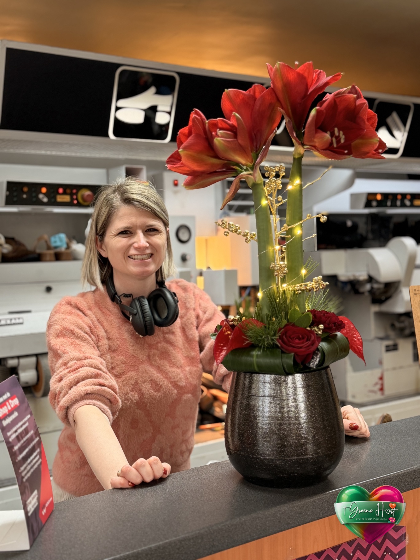 Kerstcompositie met rode amaryllis en rozen in donkere vaas