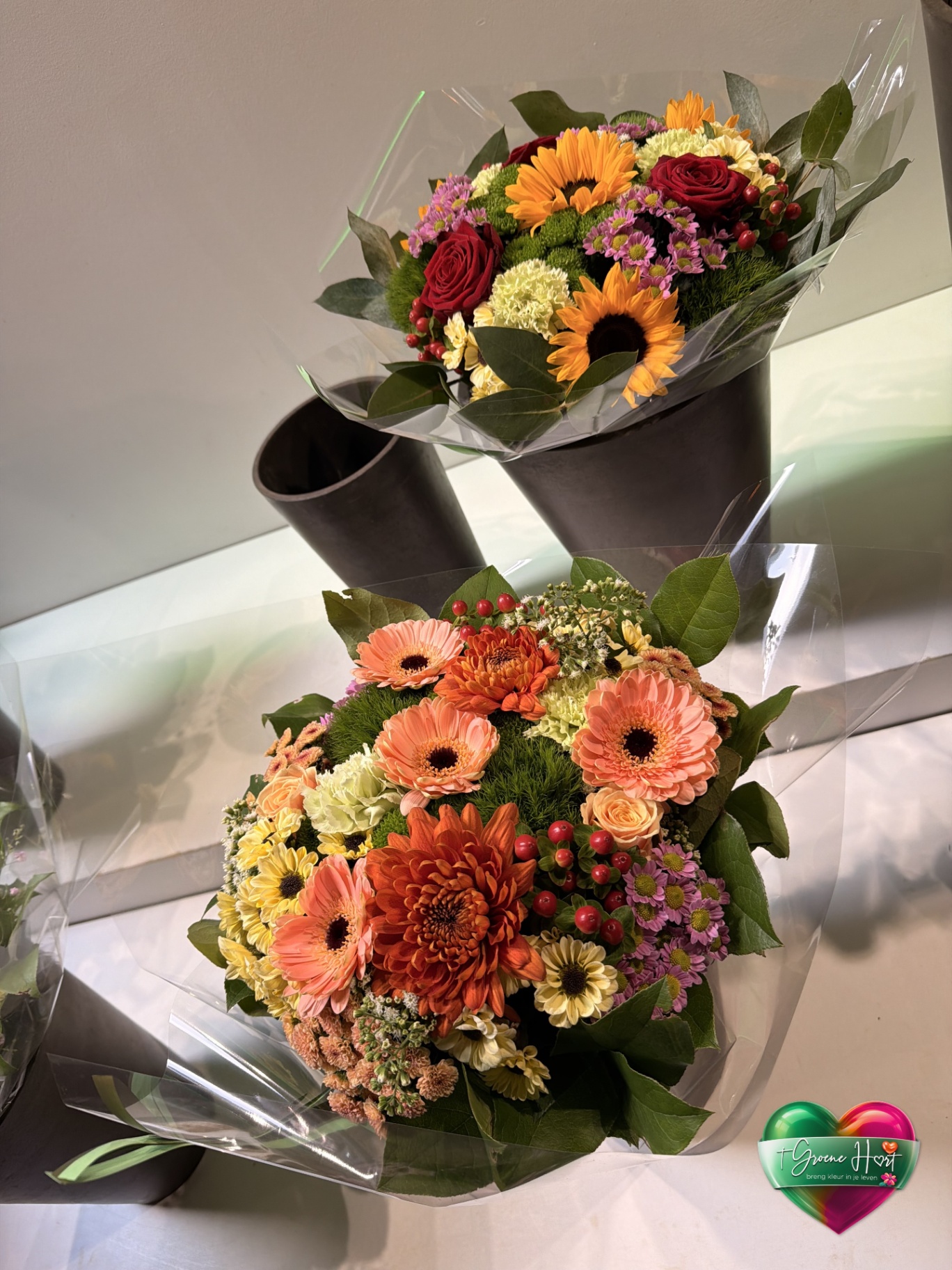 Twee kleurrijke boeketten met gerbera's, zonnebloemen en chrysanten