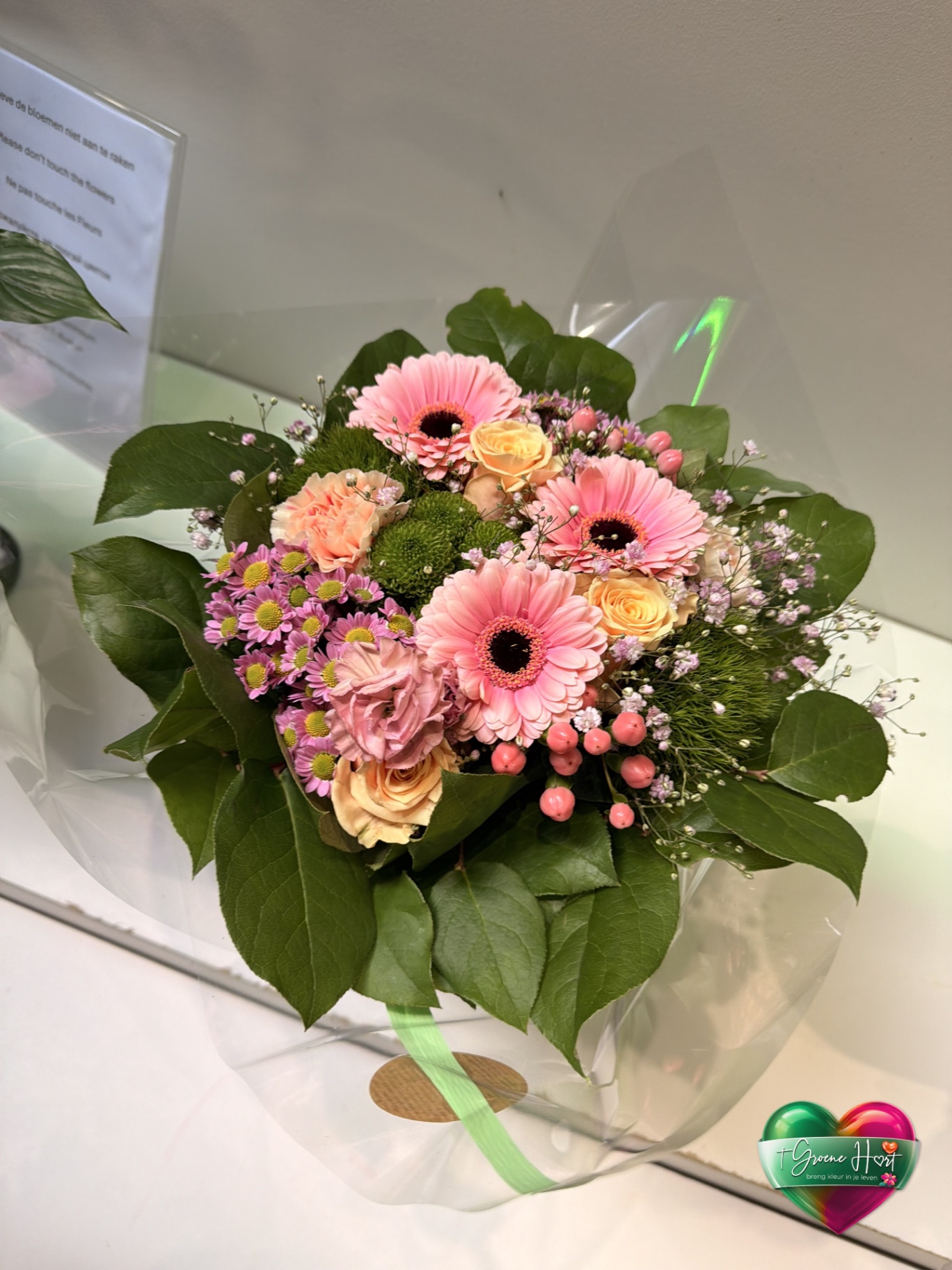 Zacht roze boeket met gerbera's, rozen en hypericum bessen